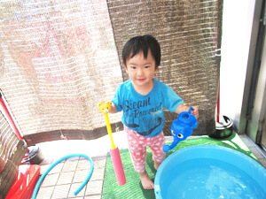 保育園で水遊びをする園児の写真