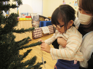 保育園でクリスマスの飾り付けをする子供の様子の写真